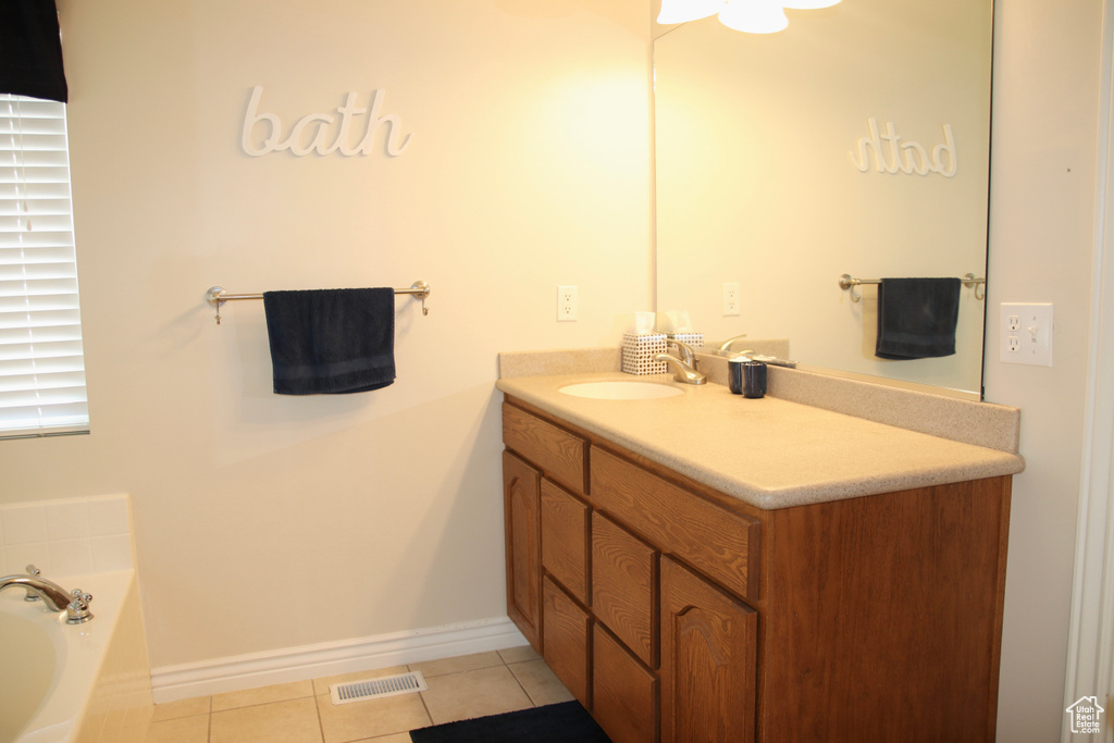 Bathroom with vanity, tile patterned floors, and a garden tub