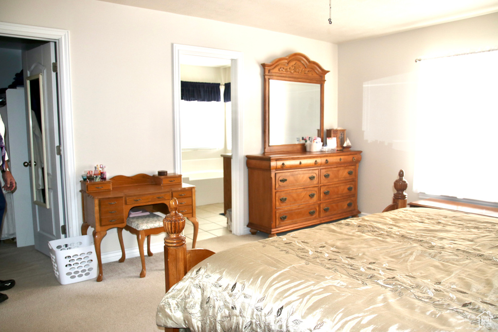 Bedroom featuring connected bathroom and light carpet
