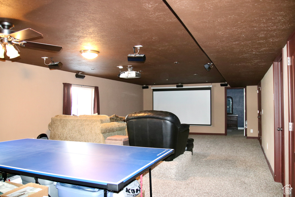 Home theater with carpet floors and ceiling fan