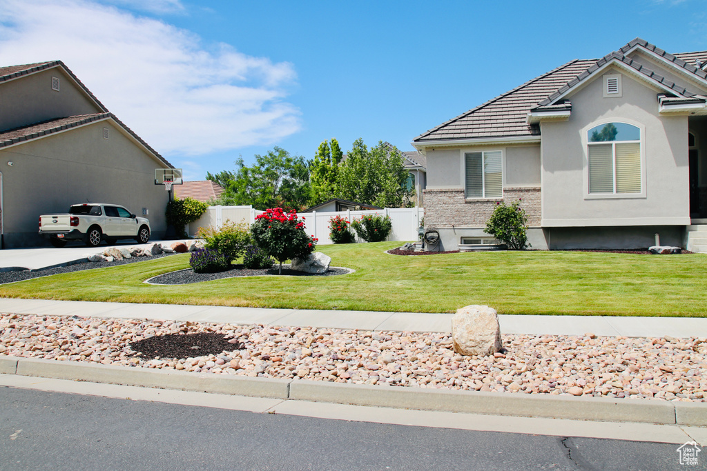 View of front of house with stucco siding, a tile roof, and concrete driveway