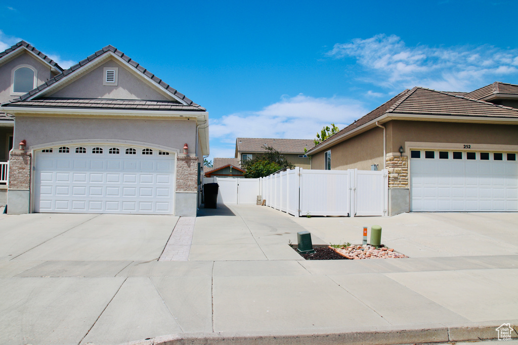 View of home\\\'s exterior with stucco siding, concrete driveway, and an attached garage