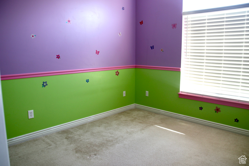 Spare room featuring carpet and baseboards