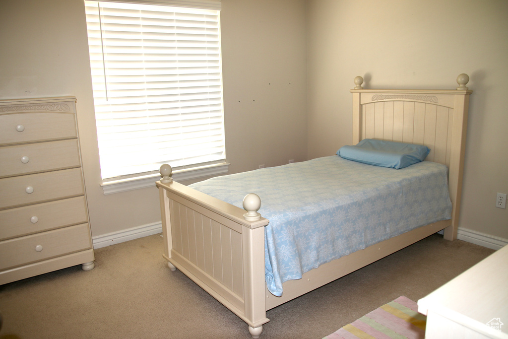 Bedroom with light colored carpet and baseboards