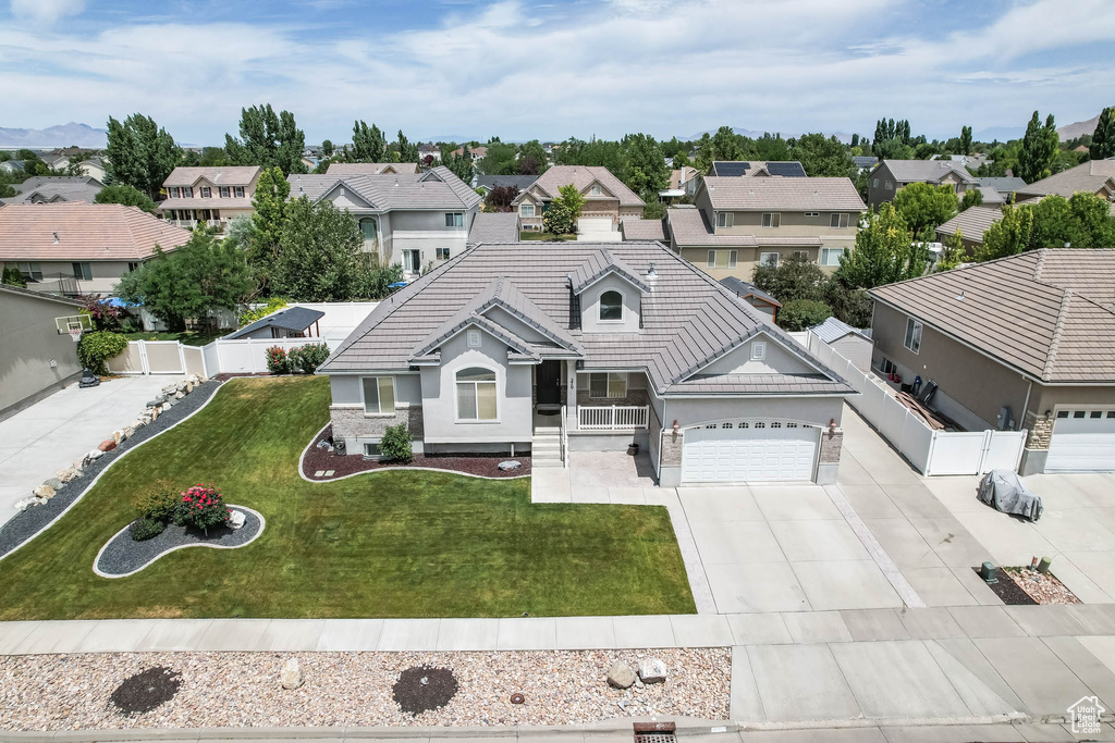 View of front of property with driveway, a tiled roof, stucco siding, and a residential view