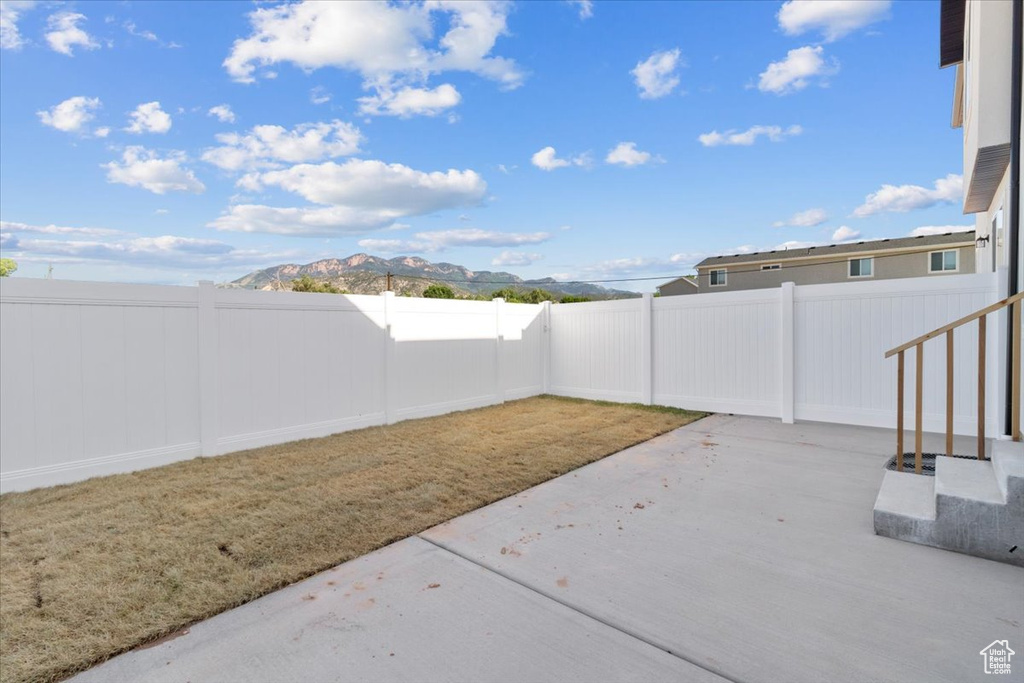 Fenced backyard featuring a patio area and a mountain view