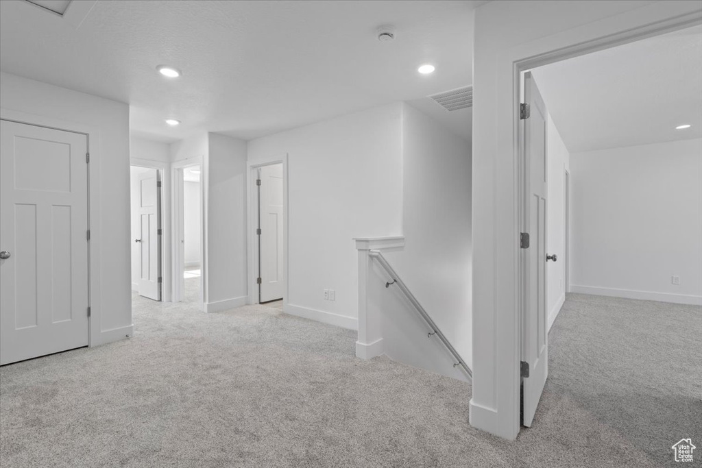 Hallway featuring an upstairs landing, carpet, and recessed lighting