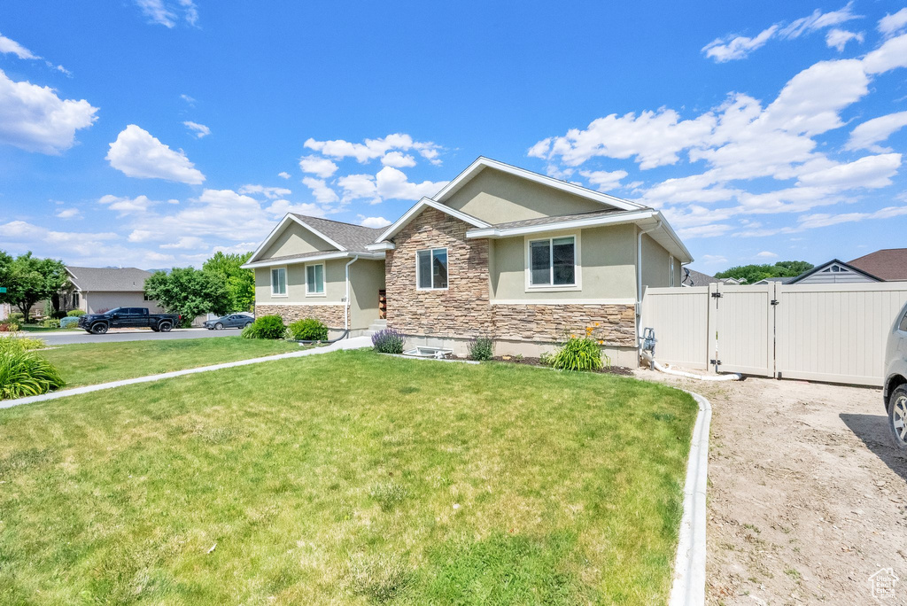 View of front of home with stone siding, a gate, and stucco siding