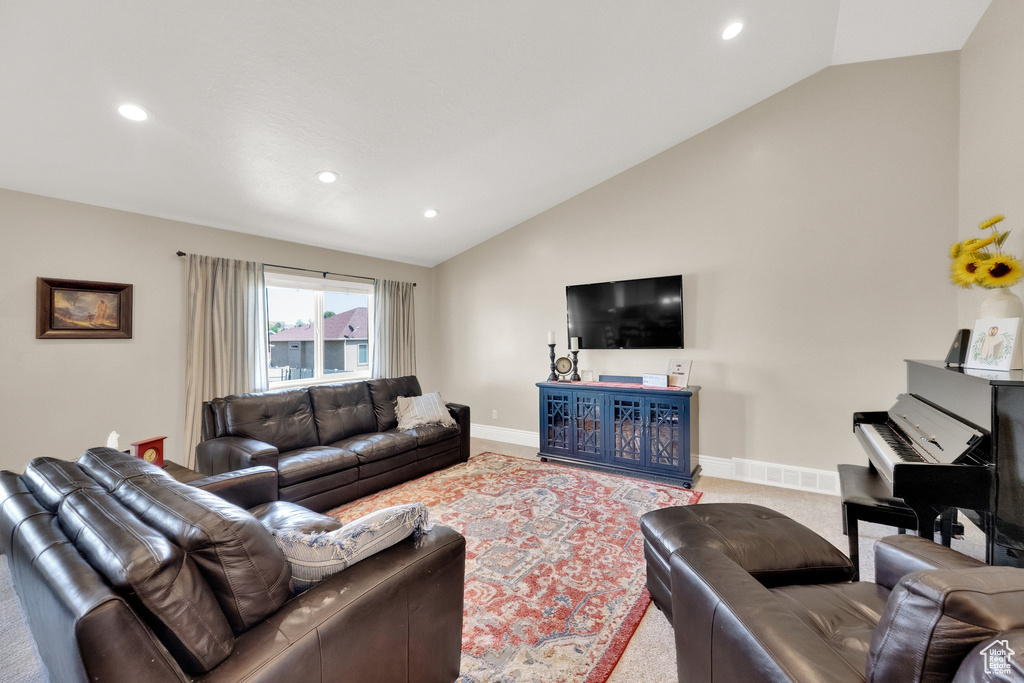 Carpeted living room with lofted ceiling and recessed lighting