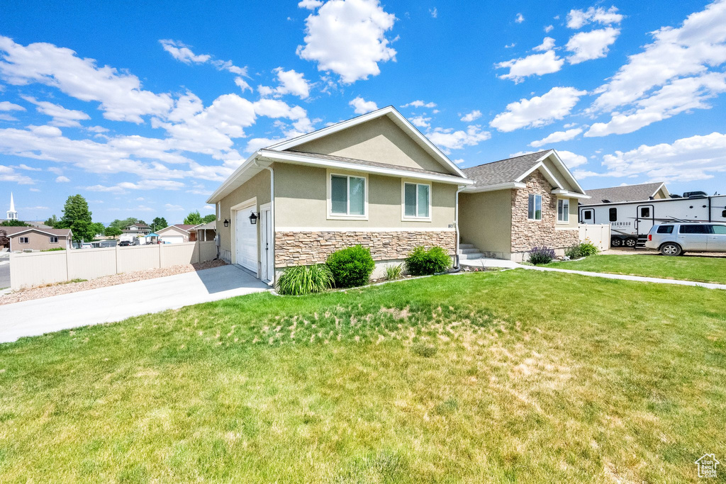 Single story home with stone siding, stucco siding, concrete driveway, and an attached garage