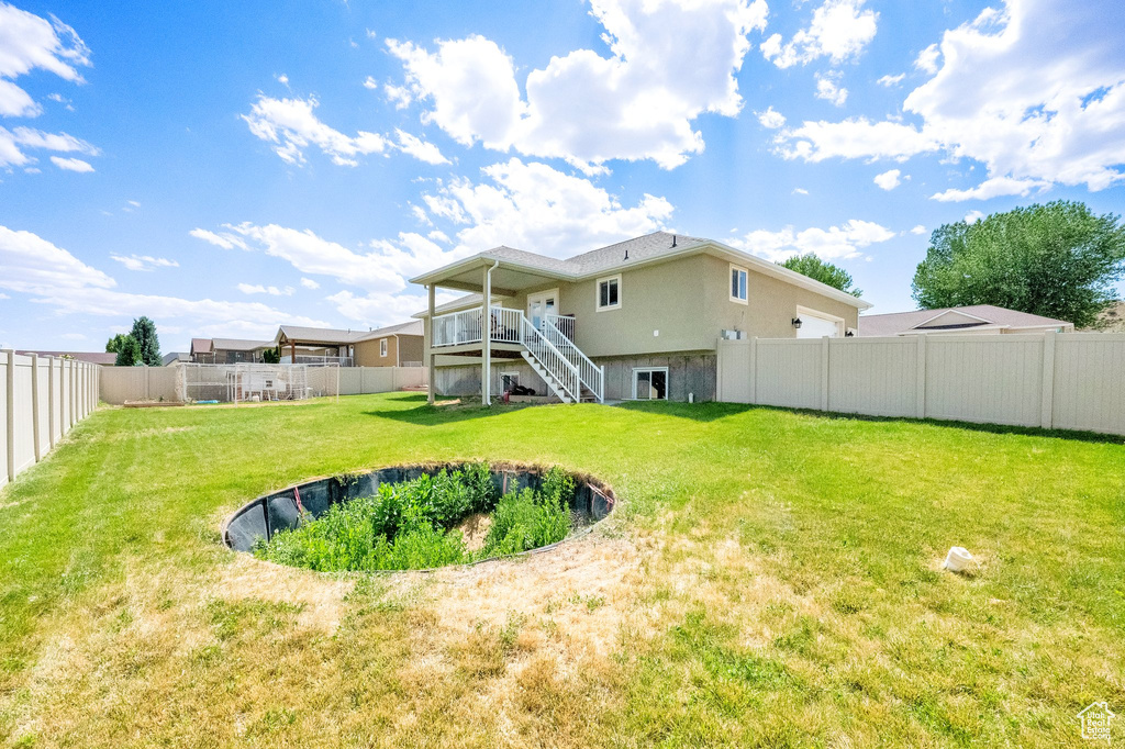 Rear view of property featuring stairway, a fenced backyard, and a deck