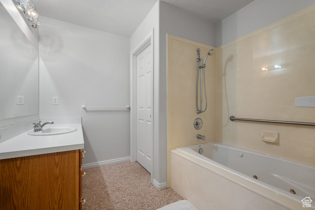 Full bath featuring vanity and a combined bath / shower with jetted tub