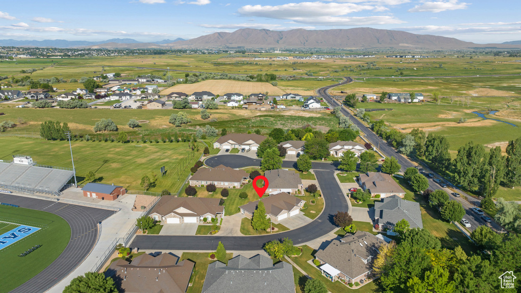 Aerial view of property and surrounding area with a mountainous background and nearby suburban area