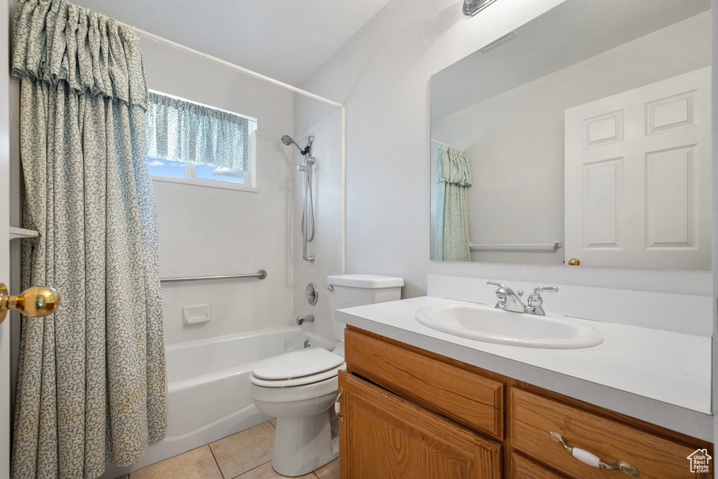 Full bathroom featuring vanity, shower / bath combo, and tile patterned flooring