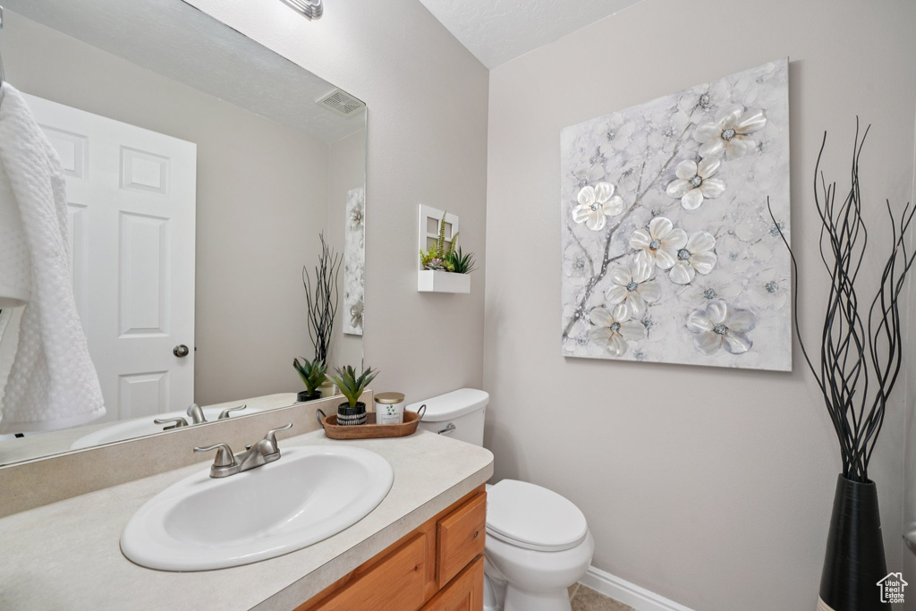 Half bathroom featuring toilet and vanity