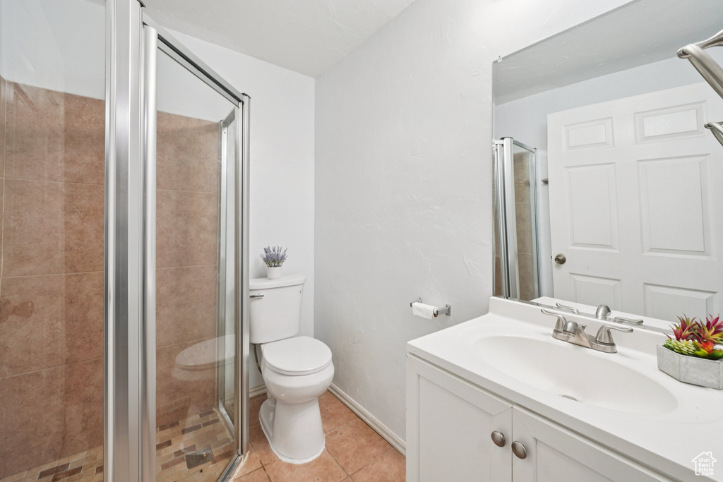 Full bathroom with vanity, a stall shower, and tile patterned floors
