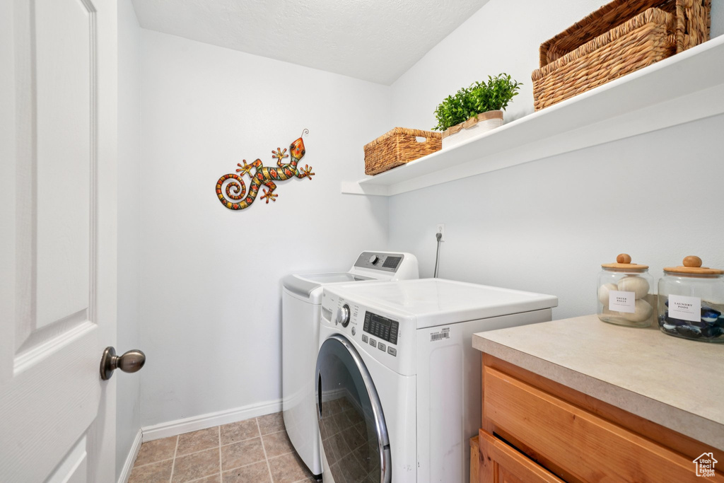 Laundry area featuring washing machine and clothes dryer and baseboards
