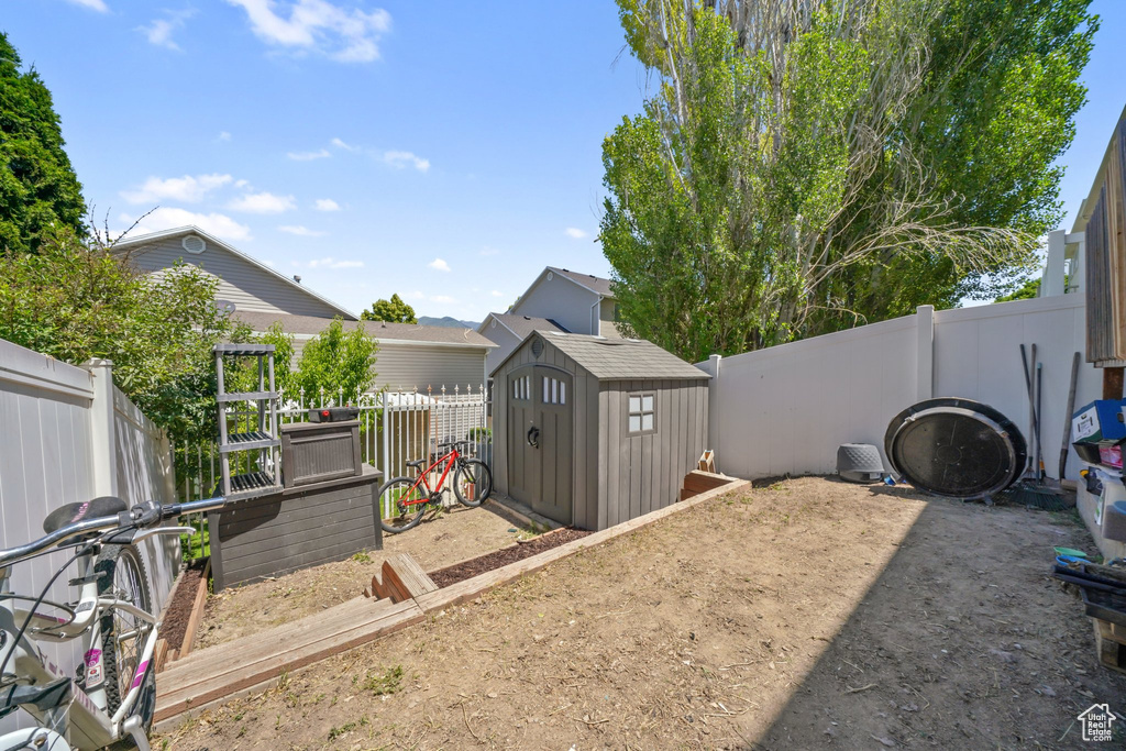 Fenced backyard featuring a storage shed