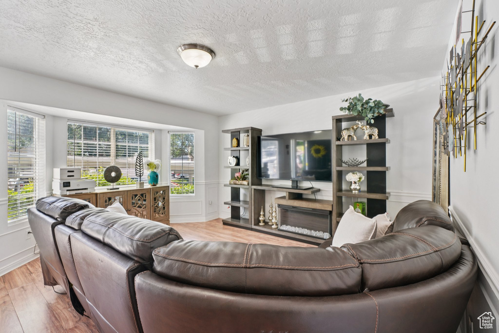 Living area featuring wood finished floors and a textured ceiling