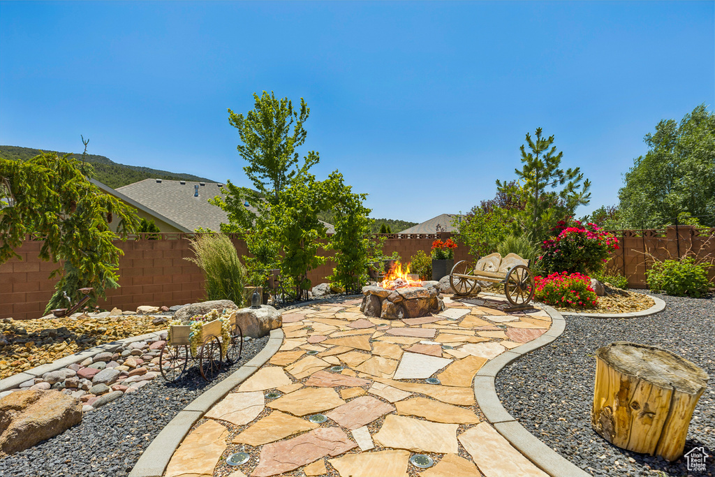 Fenced backyard featuring an outdoor fire pit and a patio