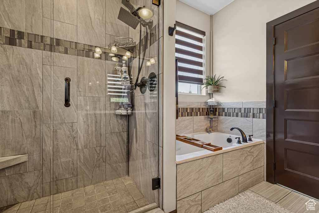 Full bathroom with a bath and a stall shower