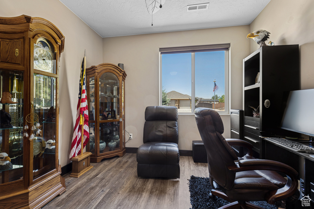 Office area with wood finished floors, a textured ceiling, and ceiling fan