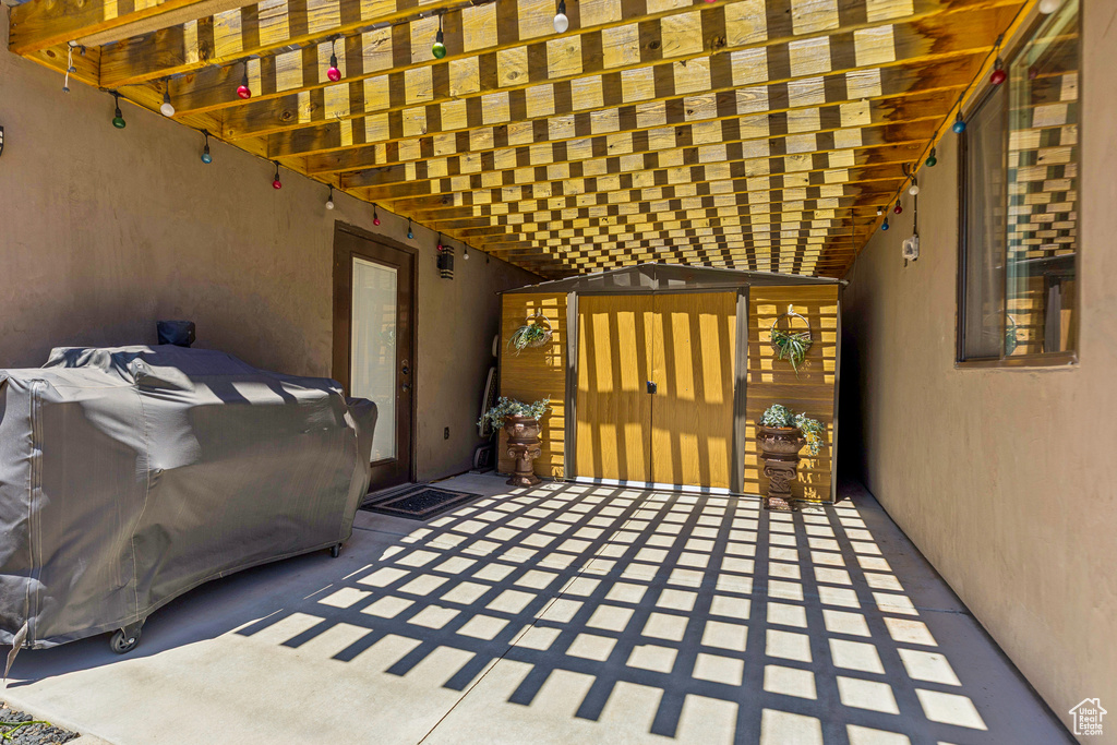 View of patio featuring a storage unit