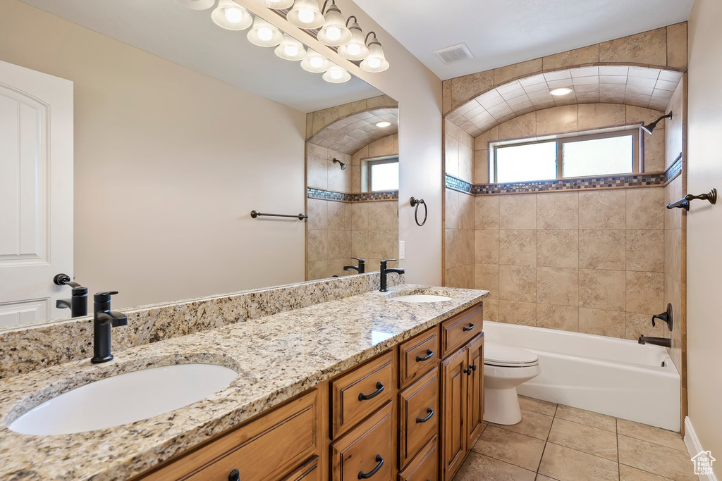 Bathroom featuring double vanity, bathing tub / shower combination, and tile patterned floors