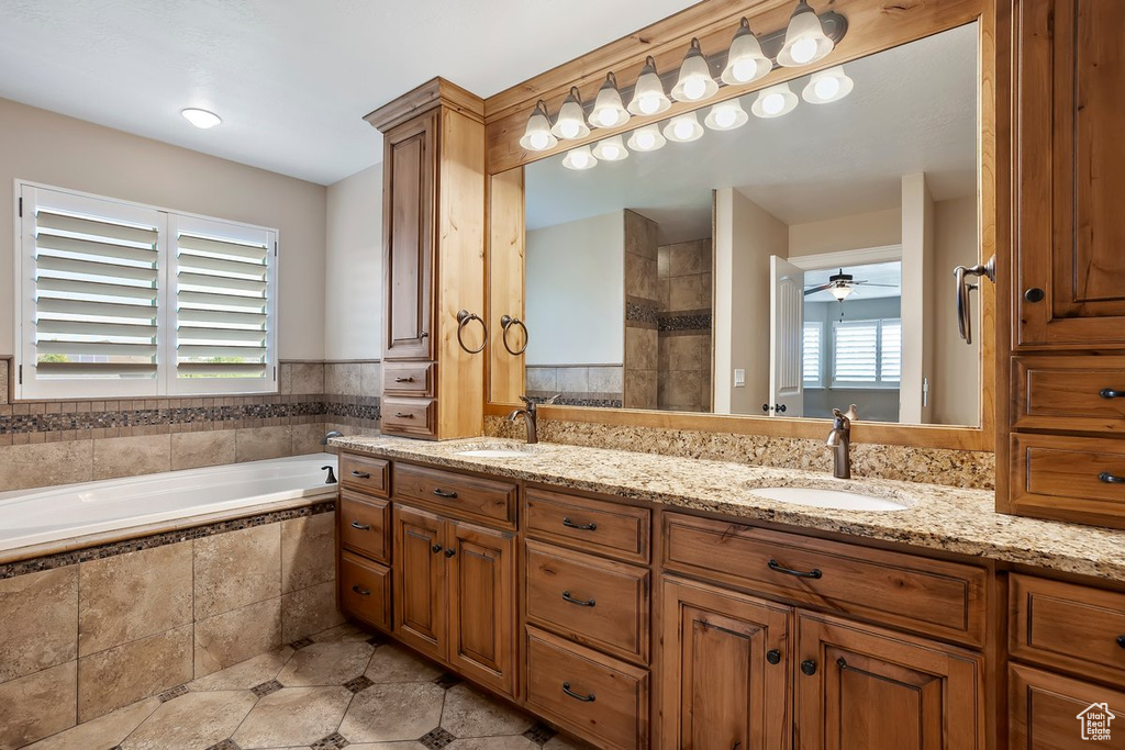 Bathroom featuring double vanity, a garden tub, tiled shower, and tile patterned flooring