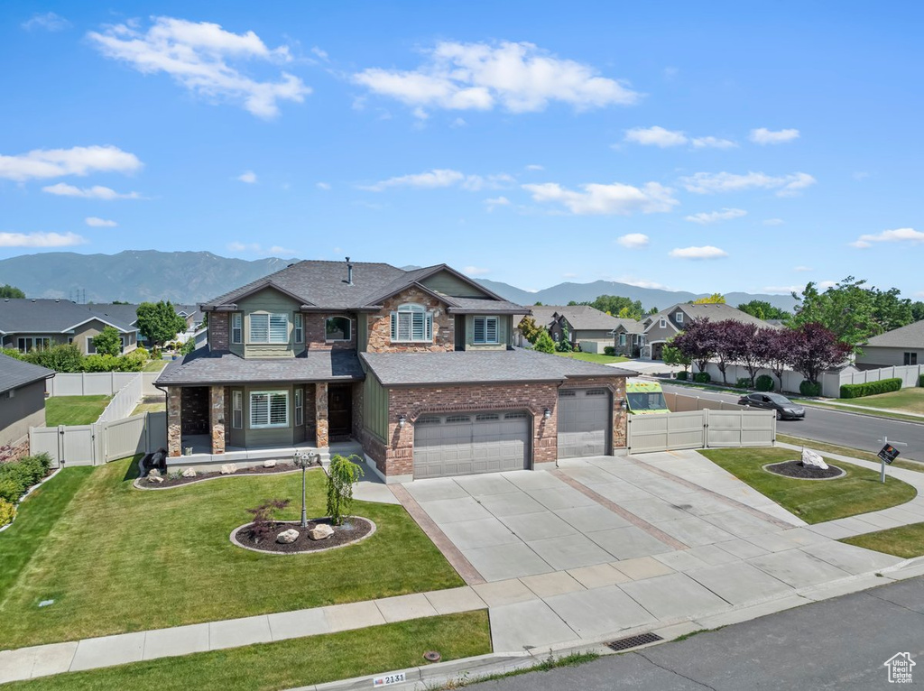 View of front of property with a gate, driveway, a mountain view, and a residential view