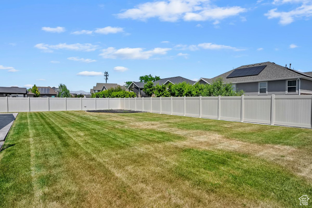 Fenced backyard featuring a residential view