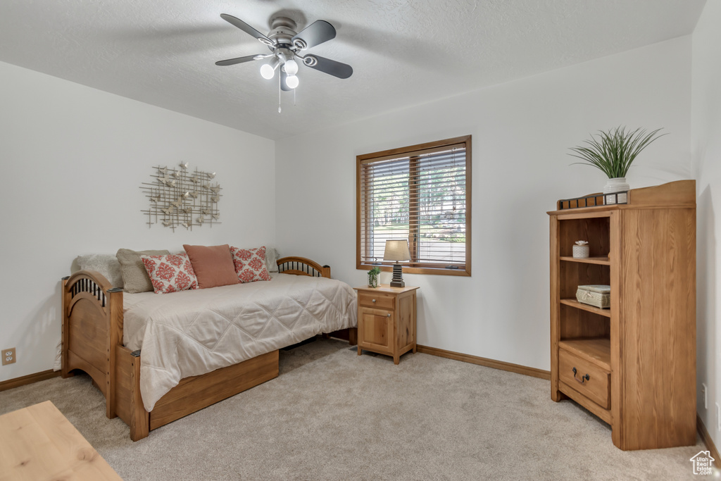 Bedroom with light colored carpet and ceiling fan