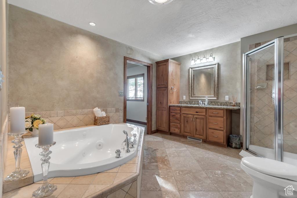 Bathroom with vanity, a jetted tub, and a stall shower