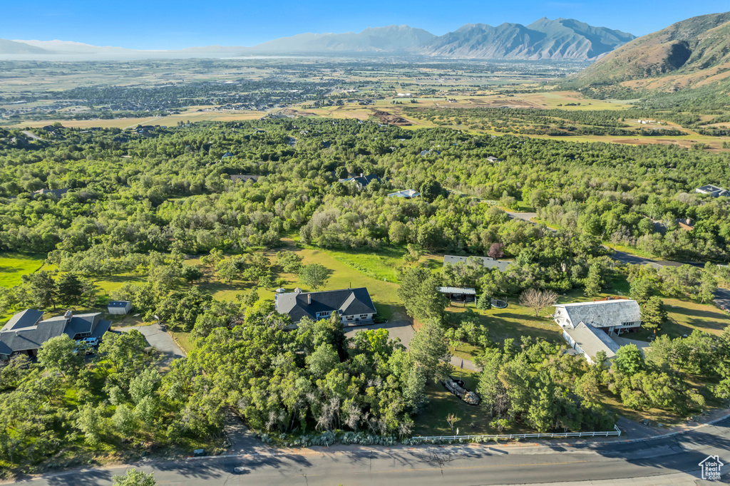 View of property location with a mountainous background and a heavily wooded area