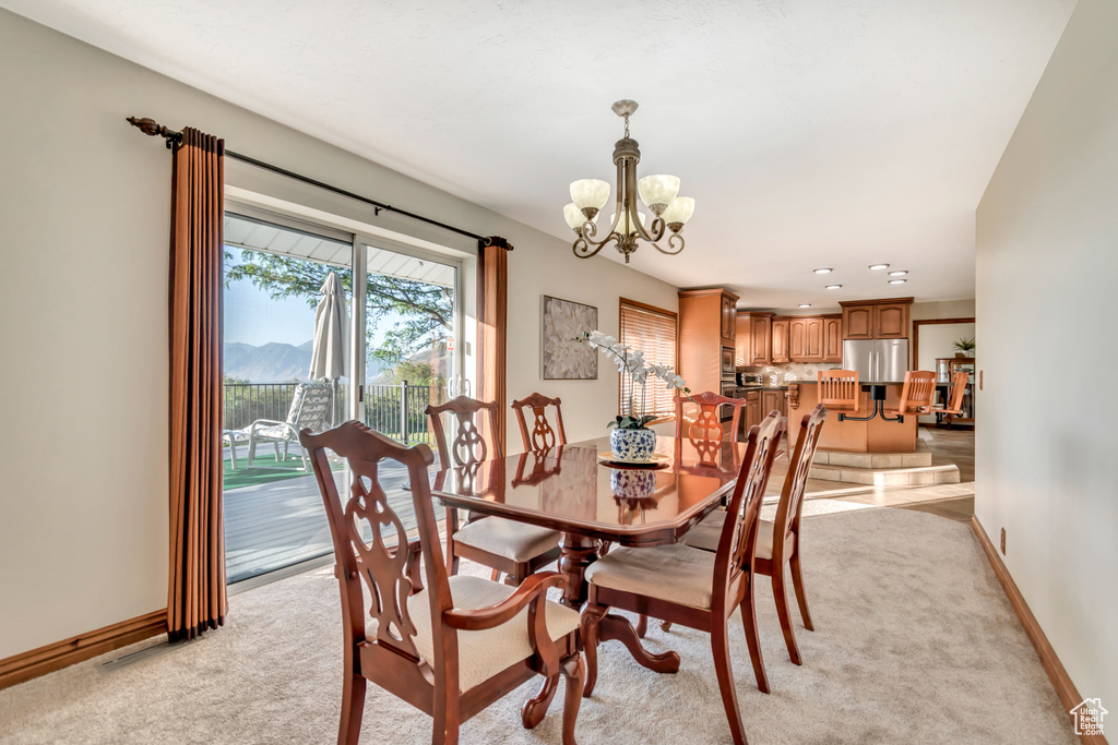 Dining area with a chandelier and light colored carpet