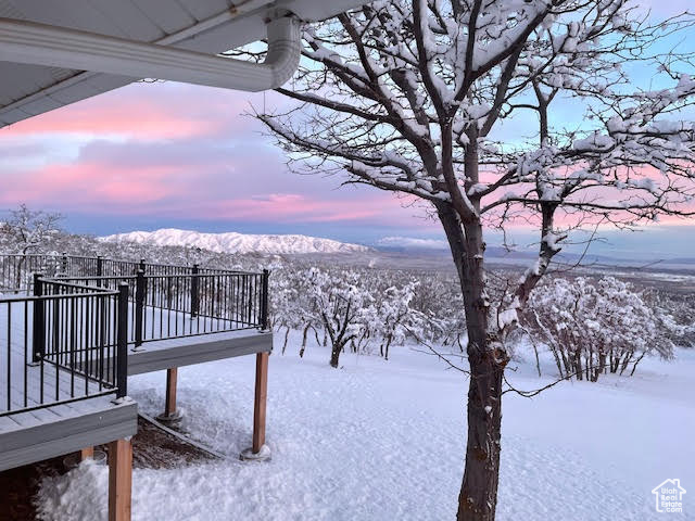 Yard covered in snow featuring a mountain view