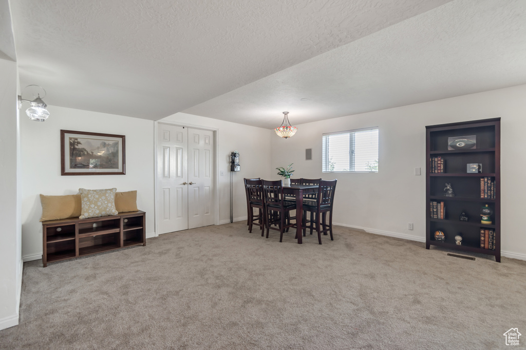 Dining area featuring a textured ceiling and carpet floors