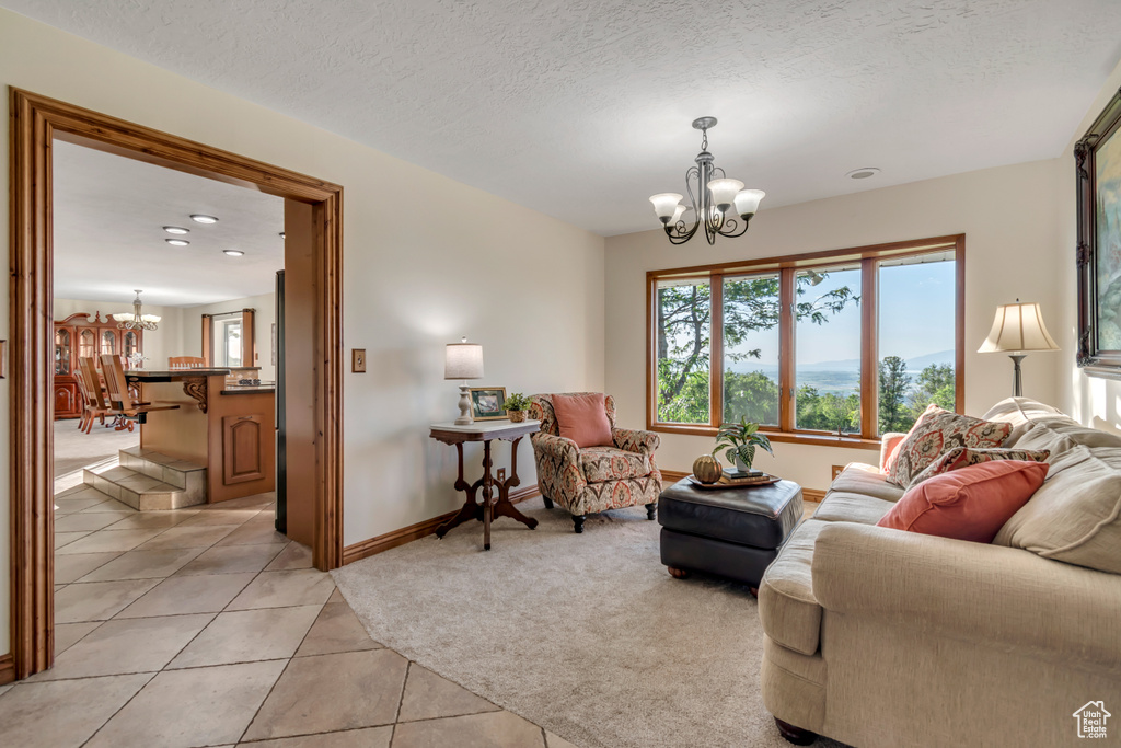 Living room with a chandelier, light tile patterned flooring, light carpet, and recessed lighting