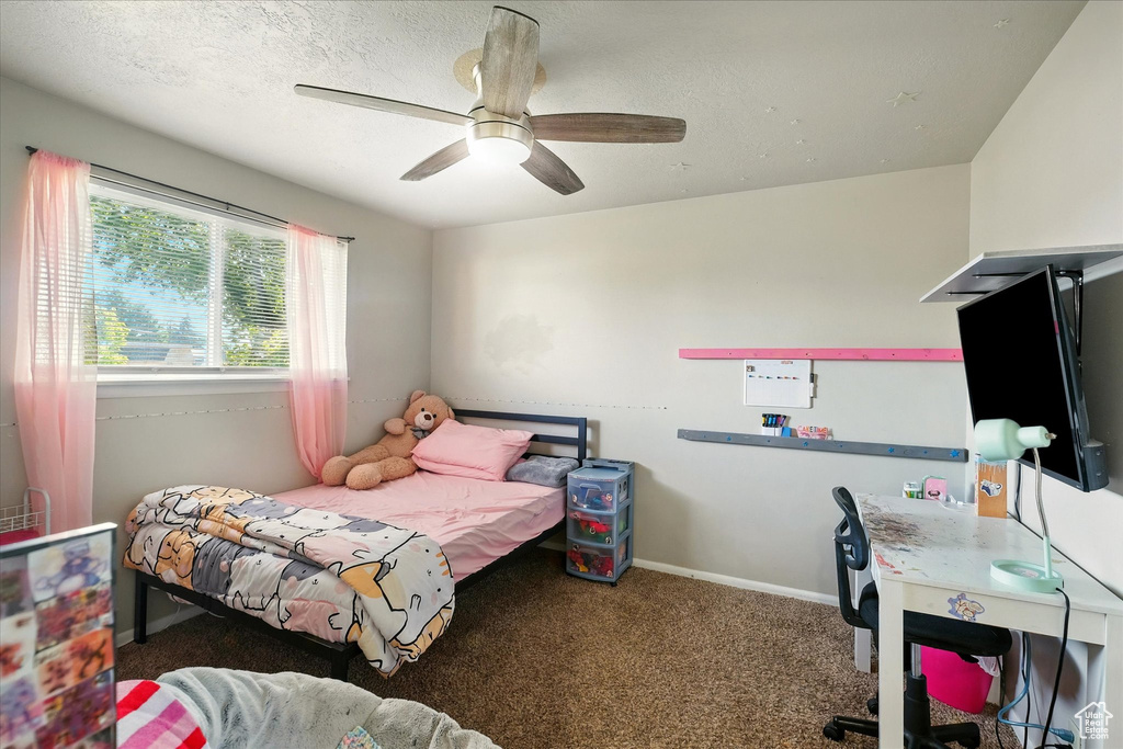 Carpeted bedroom with a ceiling fan and baseboards
