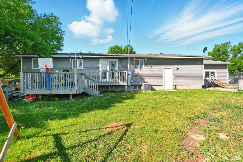 Back of property with a deck and a lawn