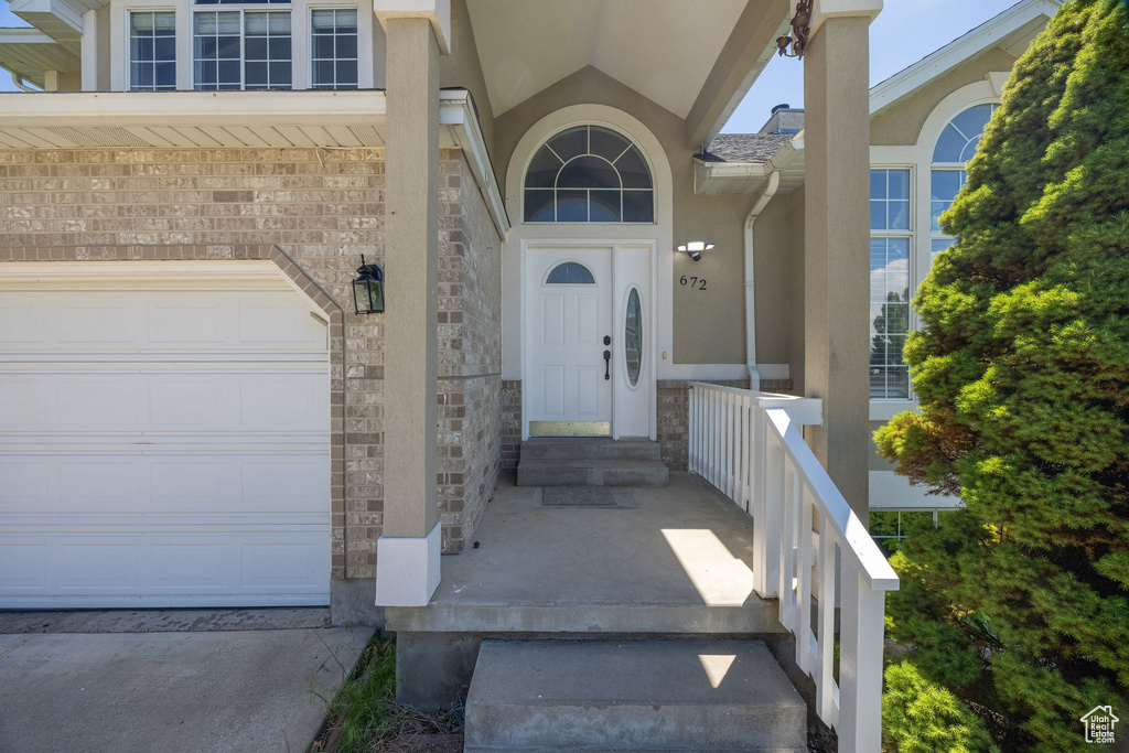 Entrance to property with stone siding and stucco siding