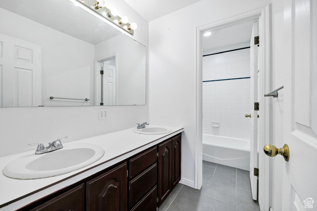 Full bathroom featuring tile patterned floors, double vanity, and  shower combination