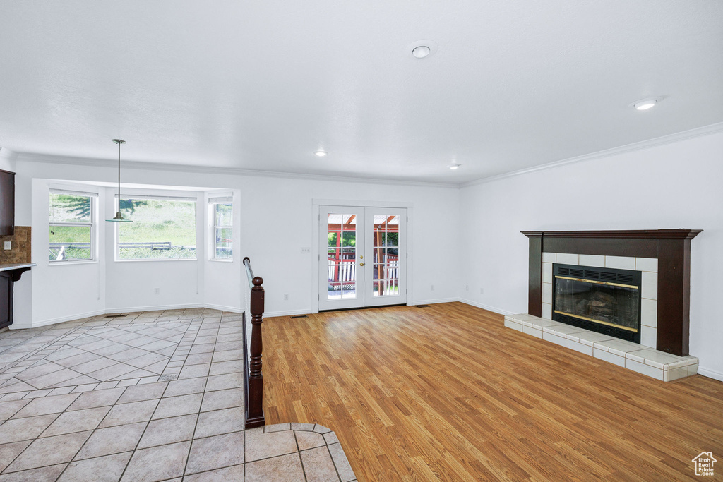 Unfurnished living room with ornamental molding, healthy amount of natural light, a fireplace, recessed lighting, and light wood finished floors