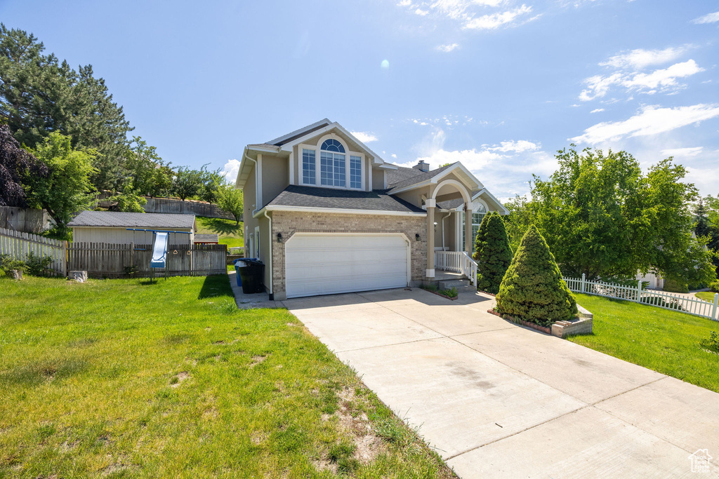 Traditional home featuring concrete driveway, brick siding, and an attached garage