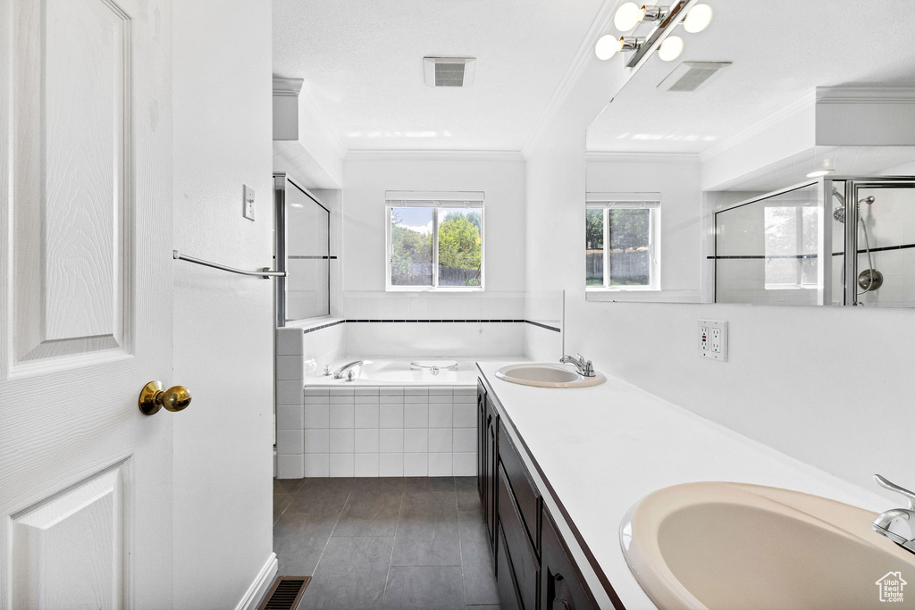 Bathroom featuring crown molding, a garden tub, double vanity, a shower stall, and wood finished floors