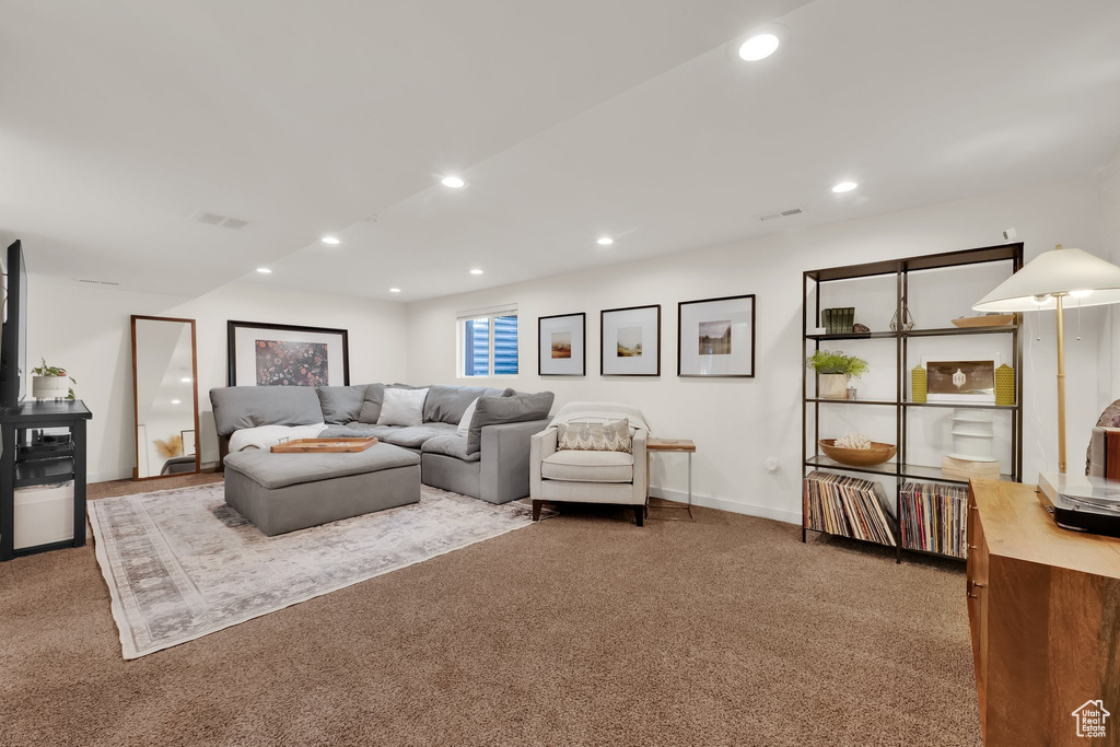 Carpeted living area with recessed lighting and baseboards