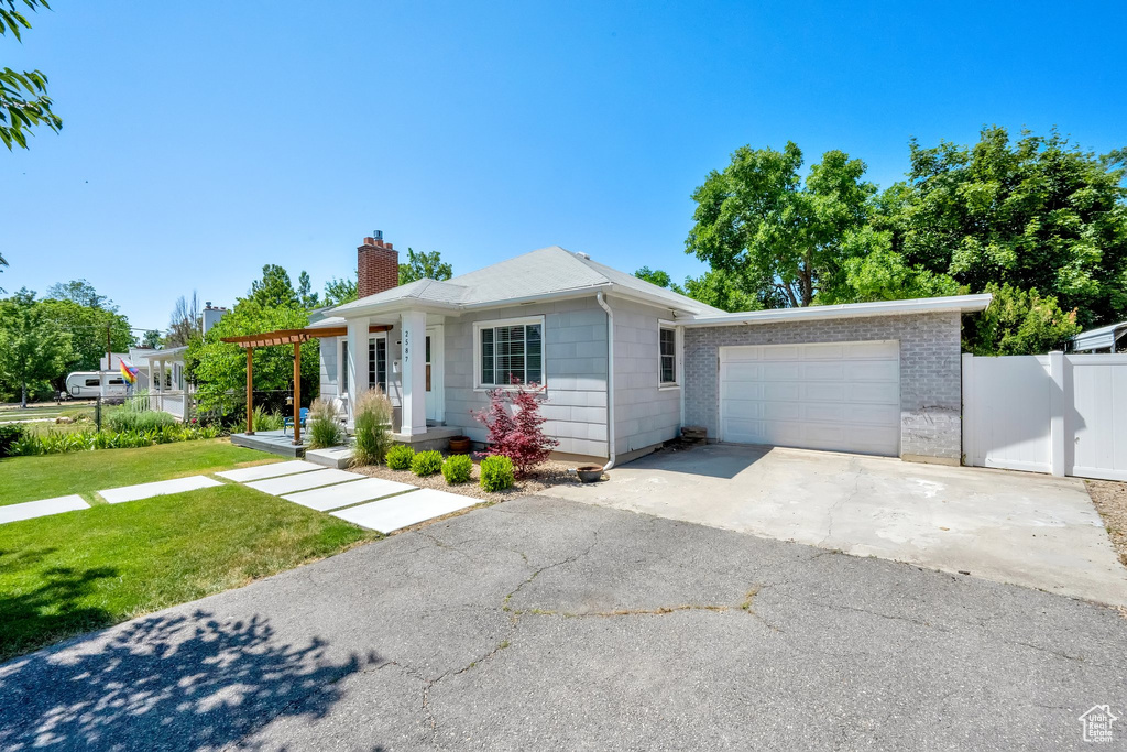 View of front of house with a chimney, a garage, and driveway