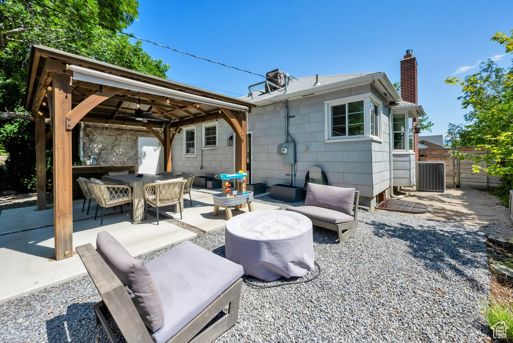 Back of property with a gazebo, ceiling fan, a chimney, a patio, and cooling unit