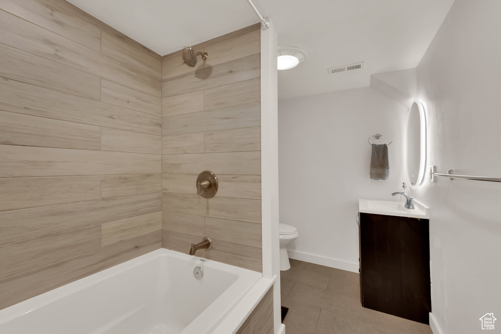 Bathroom featuring toilet, tile patterned floors, vanity, shower / tub combination, and baseboards