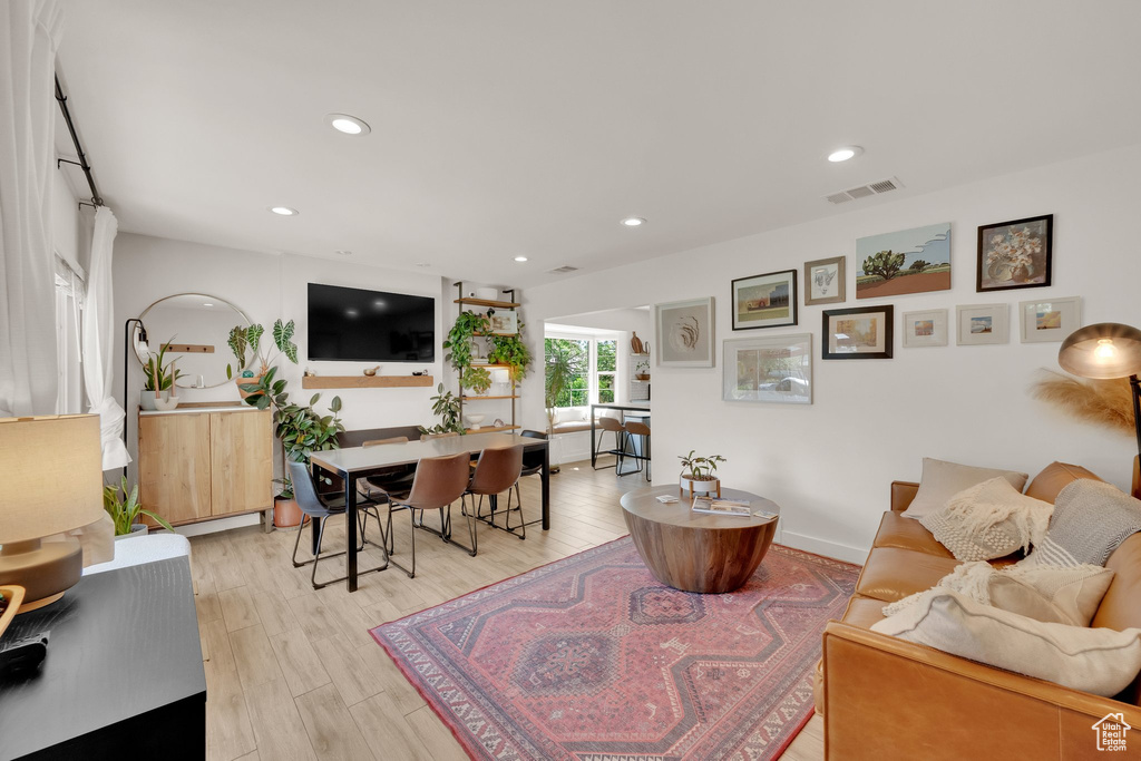 Living room with light wood finished floors and recessed lighting