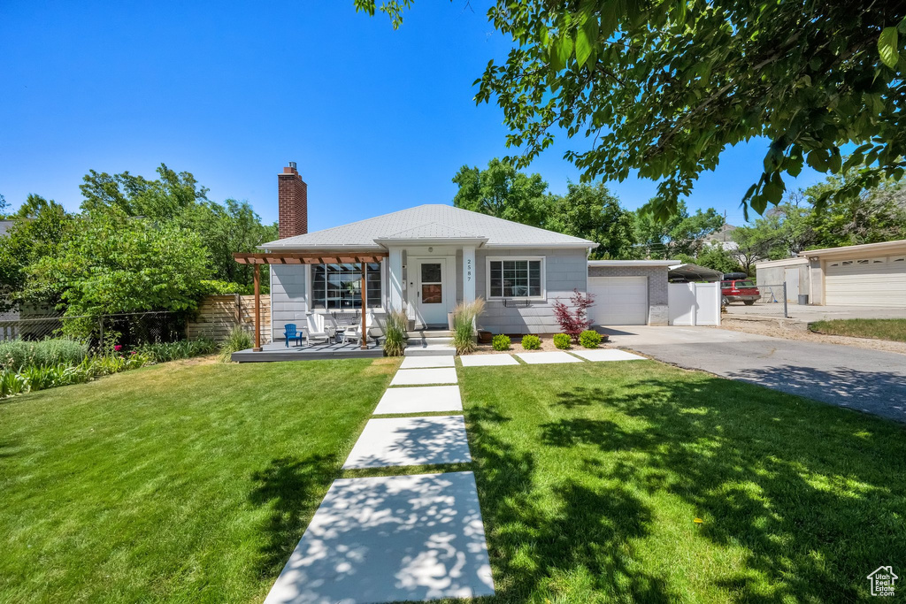 Single story home featuring a chimney, concrete driveway, and an attached garage